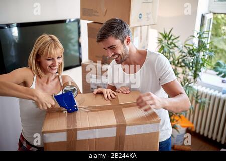 young couple packing things in boxes.  packing, moving,  concept Stock Photo