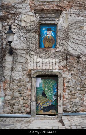 Colorful street art on an old ivy-covered facade in Bratislava Old Town, Slovakia Stock Photo