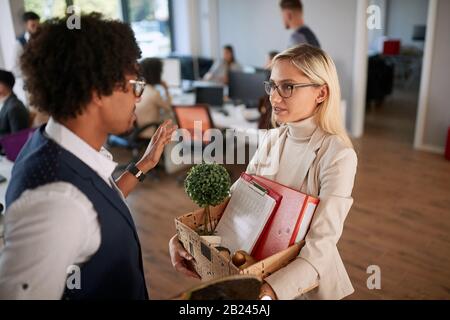 Sad woman carrying a box of things for getting fired at work. Stock Photo