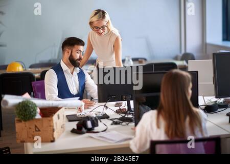 Happy business people having fun while working together on joint project . Stock Photo