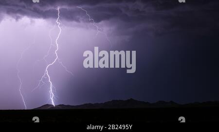 Lightning strike hitting a mountain from a monsoon storm near Phoenix, Arizona Stock Photo