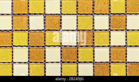 Ceramic mosaic tiles with orange, yellow and white squares to decorate the kitchen, bathroom or pool. Stock Photo