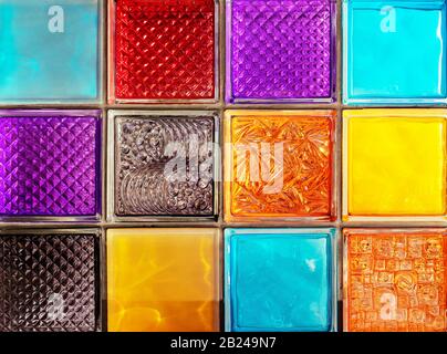 Colored glass blocks with embossed patterns. Multi-colored glass squares. Stock Photo