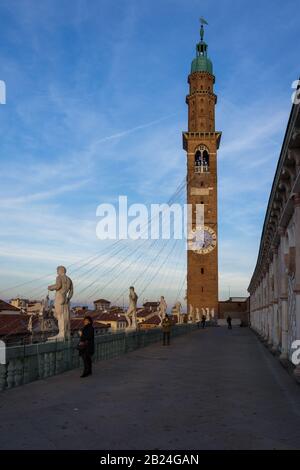 Vicenza, Italy. December 26, 2016:  Statues and Torre Bissara on the roof of the Palladian Basilica at sunset Stock Photo