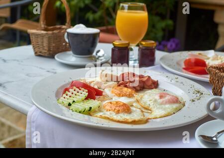 Rich, delicious breakfast with a juice and a cappuccino served outdoor Stock Photo