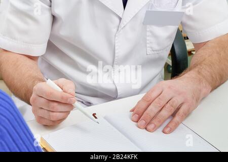 Cropped view of doctor writing in notepad during consulting a patient Stock Photo