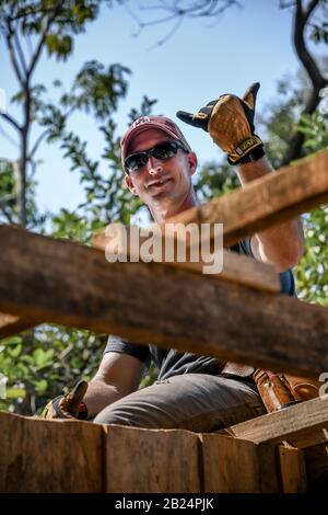 man working on house for poor family in Guatemalan village Stock Photo