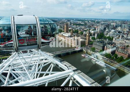 A city skyline of London, England, UK as seen from the London Eye Ferris Wheel.  Tourists in other pods of the London Eye are in the foreground. Stock Photo