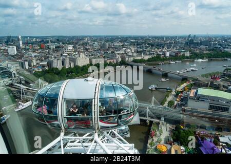 A city skyline of London, England, UK as seen from the London Eye Ferris Wheel.  Tourists in other pods of the London Eye are in the foreground. Stock Photo