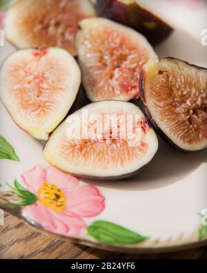 Close Up of Halved Figs on a Flower Pattern Plate Stock Photo