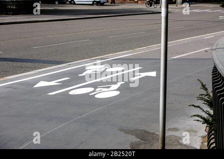 Bicycle sign on gray asphalt showing two cycles and direction arrows - special dedicated safety lane for cyclist in new urban environment Stock Photo