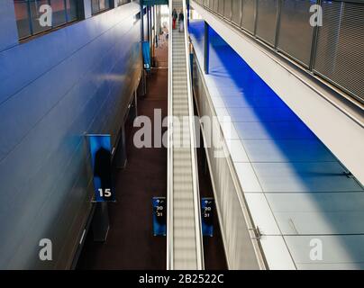 View of people silhouettes ascending on the fast escalators inside large cinema multiplex building Stock Photo