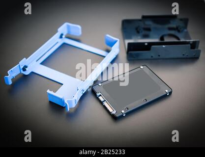 New 2,5 inch SSD fast solid state drive near SSD adapter rail for HDD or SDD conversion cradle for 3.5 inch Drive Bays Stock Photo