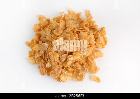 Dry corn flakes top view. Thin cornflakes in glaze on a white background. Quick breakfast cereals. Stock Photo