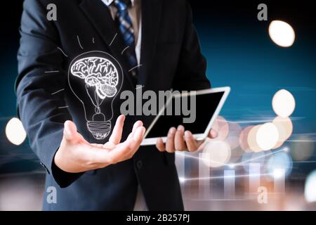 business man holding hand with drawing brain in bulb Stock Photo