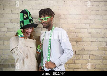 Happy Young Couple Wearing Costumes to Celebrate St. Patrick's Day. Stock Photo