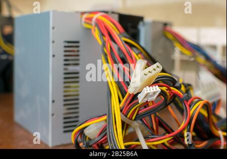 closeup, connectors with wires of the standard power supply from the computer, which stands separately on the table Stock Photo