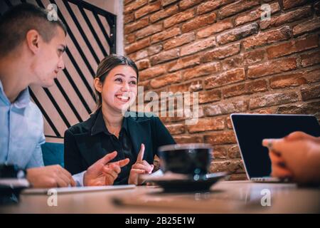Happy businessman and businesswomen having teamwork meeting for developing new strategies in a cafe. Stock Photo