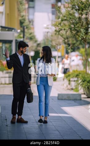 Business, communication and people concept - couple, colleagues or office workers talking on city street Stock Photo