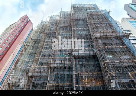 Renovation of building facade with scaffolding. Construction of high-rise building Stock Photo