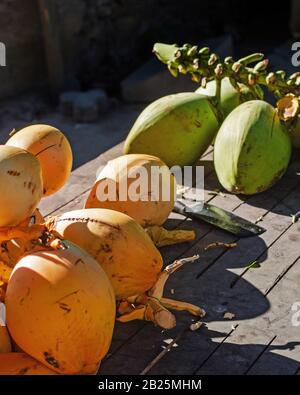 Yellow and green coconut bunches on a market in Asia Stock Photo