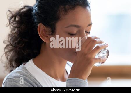 Thirsty african American woman drinking mineral water Stock Photo