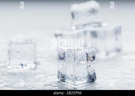 Ice cubes with water drops scattered on a white background, top view. Refreshing ice. Isolate Stock Photo
