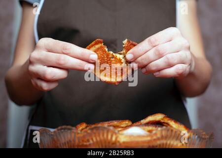 the girl the cook holds in his hands a fried pancake and tastes. concept: home baking. Stock Photo