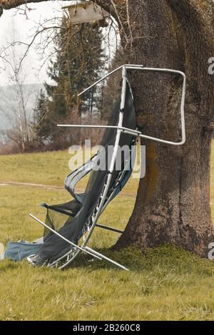 damage trampoline because of hurricane stopped from a tree Stock Photo