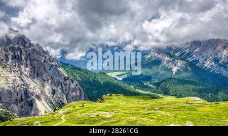The small lake of Misurina seems to get lost in the large valley seen from the Auronzo refuge Stock Photo