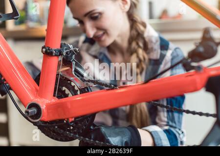 Bike technician in her workshop working on bicycle Stock Photo