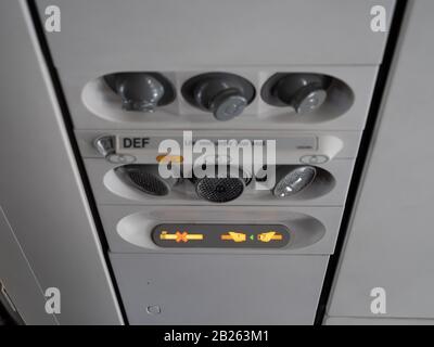 Seatbelt sign lit at the overhead pannel Stock Photo