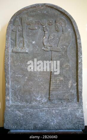 Bel-harran-beli-usur is praying in front of divine symbols. Stele with inscription and relief. 8th BCE. Limestone. Tel-Abda. Marble. Iraq. Stock Photo