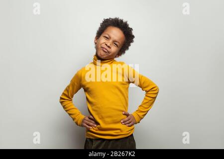 Small black child boy grimacing on white background Stock Photo