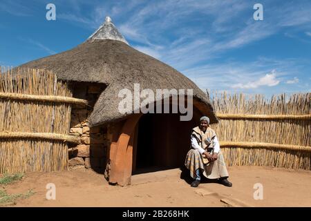 Basotho man in front of traditional hut, Thaba Bosiu Cultural Village, Lesotho Stock Photo