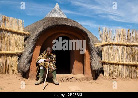 Basotho man in front of traditional hut, Thaba Bosiu Cultural Village, Lesotho Stock Photo