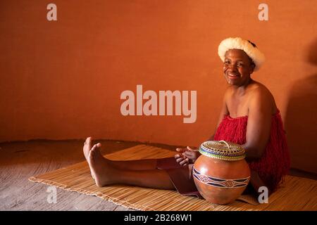Basotho woman in a traditional hut, Thaba Bosiu Cultural Village, Lesotho Stock Photo