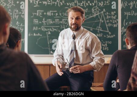 Cheerful bearded professor having a casual informal conversation with students during math seminar Stock Photo