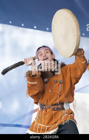 Aborigine dancer in traditional clothes native people expression dancing with tambourine. Concert Koryak Dance Ensemble Mengo. Kamchatka Peninsula Stock Photo