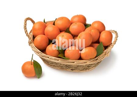 Basket with fresh mandarin fruit and leaves isolated on white background Stock Photo