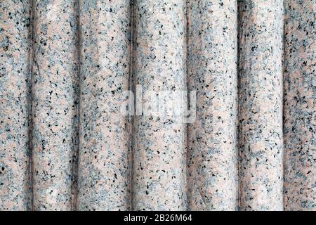 Carved granite texture with vertical curve shapes and grey black and pink veins Stock Photo