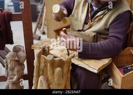 Old hands carving wood with a chisel Stock Photo