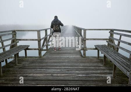 Male person strolling on a boardwalk at Unesco World Heritage 'Federsee' in Bad Buchau, Germany Stock Photo