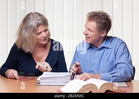 Mature woman and man discussing a project.. Could be lawyer, consultant or accoutant Stock Photo