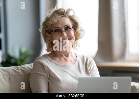 Portrait of smiling senior woman using laptop Stock Photo