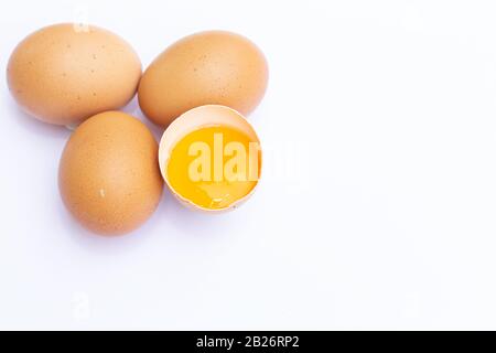 Four brown Eggs with one has broken isolated on white background Stock Photo