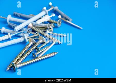 Many different nails screws nuts bolts on blue background of the copy space. Construction and repair concept Stock Photo