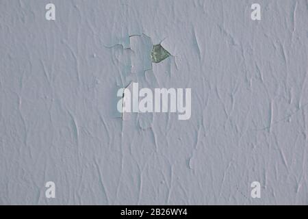 Cracked painted grey wall covered with grey texture, natural background. Old concrete texture with cracks and holes. Stock Photo