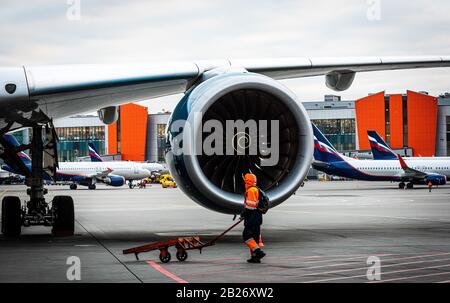 October 29, Moscow, Russia, Airport employee at the engine Rolls-Royce Trent XWB of a wide-body aircraft Airbus A350 XWB at Sheremetyevo Airport. Stock Photo