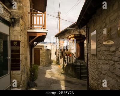 One of the narrow streets in the attractive ancient mountain village of Omodos located in the Troodos Mountains of Cyprus with lovely stone built prop Stock Photo